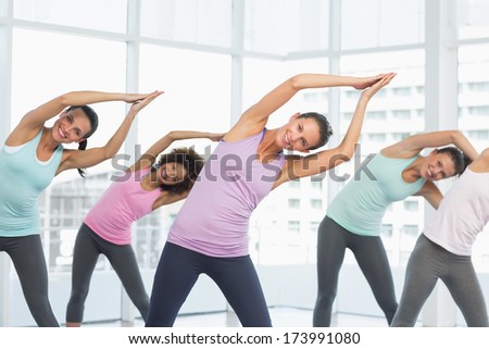 Portrait of smiling young women doing pilate exercises in the fitness studio
