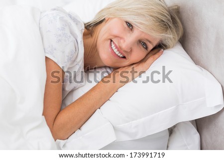 Closeup portrait of a pretty mature woman resting in bed