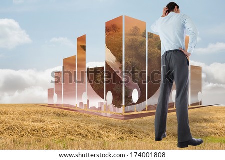 Thinking businessman with hand on head against bright brown landscape