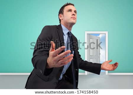 Businessman posing with arms out against door opening showing blue sky