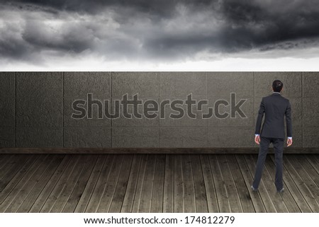 Asian businessman against balcony and stormy sky