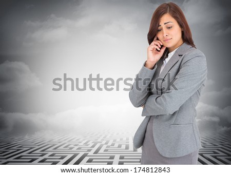 Worried businesswoman against clouds over maze