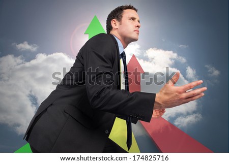 Businessman posing with arms out against colorful arrows pointing up against sky