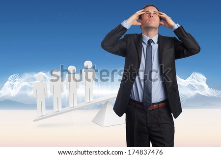 Stressed businessman with hands on head against white human resource scales in desert