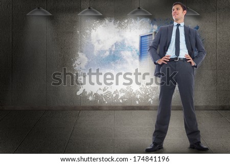 Happy businessman with hands on hips against splash on wall revealing server tower