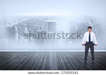 Sad tradesman showing his empty pockets against city scene in a room