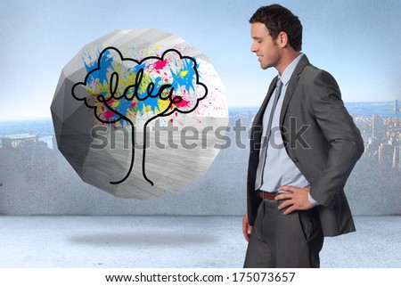 Smiling businessman with hand on hip against city scene in a room