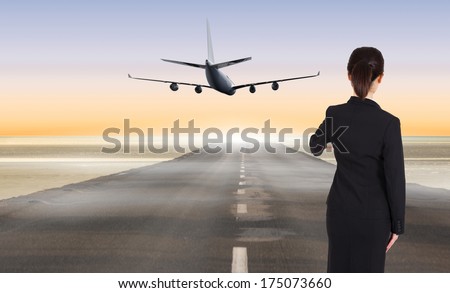 Businesswoman pointing against road leading out to the horizon