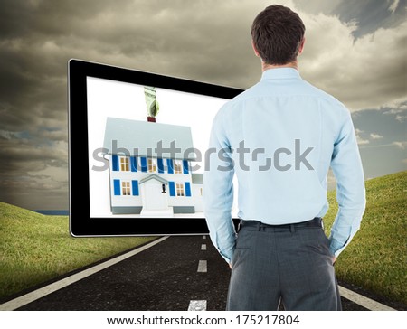 Businessman standing with hands in pockets against highway under cloudy sky