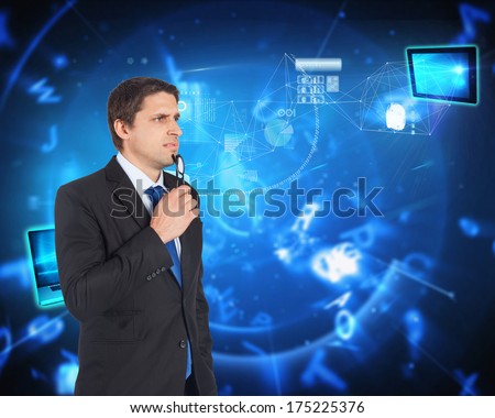 Thinking businessman holding glasses against blue background with letters
