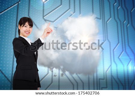 Smiling businesswoman pointing against circuit board on futuristic background