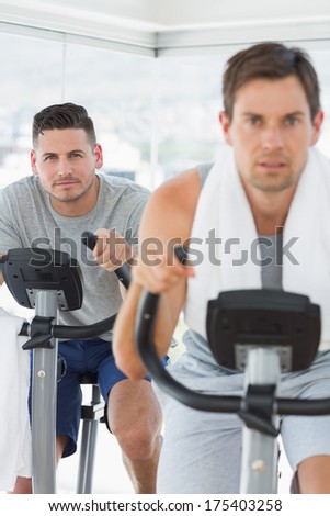 Portrait of determined man using exercise bike at gym