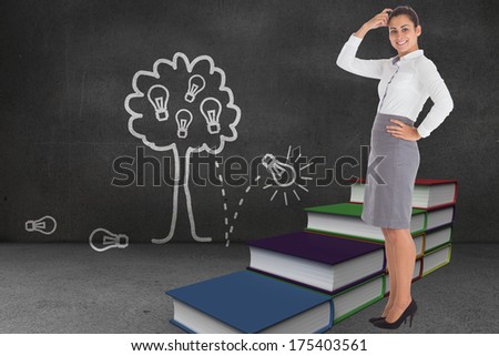 Smiling thoughtful businesswoman against steps made of books in front of idea tree drawing