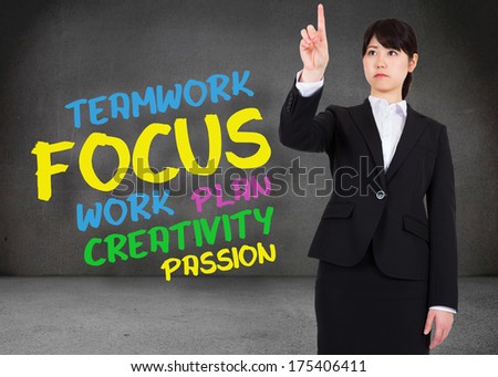 Focused businesswoman pointing against buzz words in room