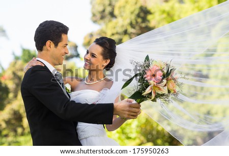 View of a romantic newlywed couple dancing in the park
