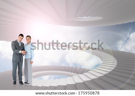 Business partners with clipboard against winding staircase in the sky