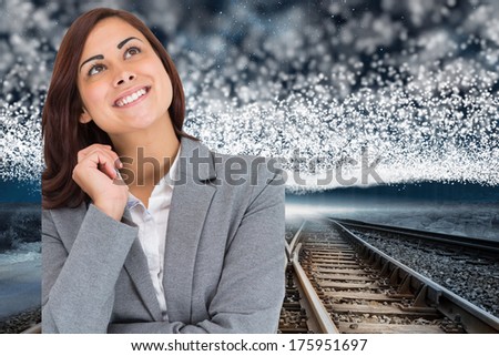 Smiling thoughtful businesswoman against train tracks under blanket of bright stars