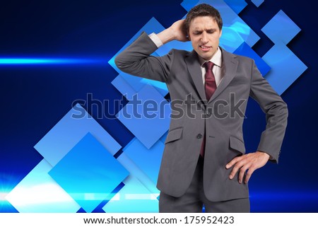 Thinking businessman scratching head against blue cube pattern
