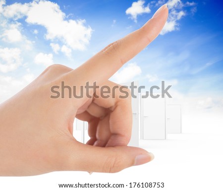 Female hand pointing against opening door in sky