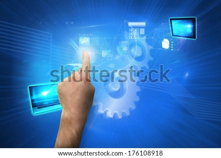 Hand pointing against shiny cogs on blue background