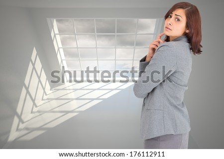 Worried businesswoman against blue sky seen through window