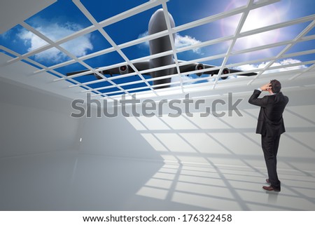Stressed businessman with hands on head against airplane flying over window