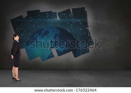 Smiling businesswoman against display on wall showing global technology graphic