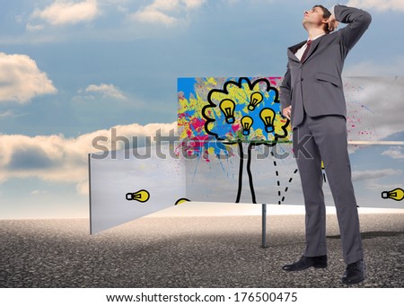 Thinking businessman scratching head against green road signs against blue sky