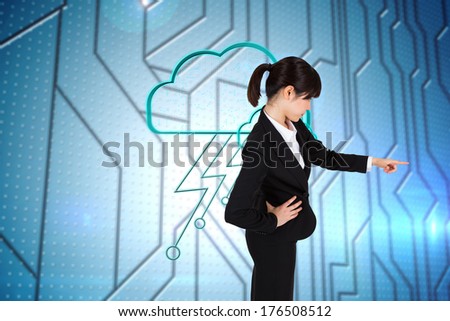 Focused businesswoman pointing against circuit board on futuristic background