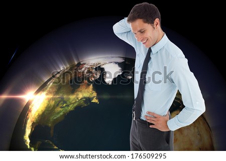 Thinking businessman scratching head against glowing earth, elements of this image furnished by NASA