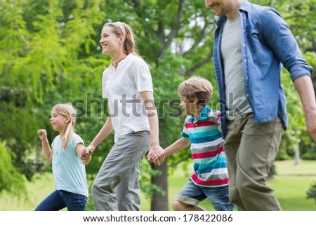 Side view of parents and kids walking in the park