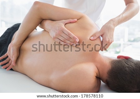 Cropped image of physiotherapist massaging man in hospital