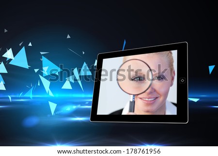 Businesswoman holding magnfying glass on tablet screen against small pyramids on technical background