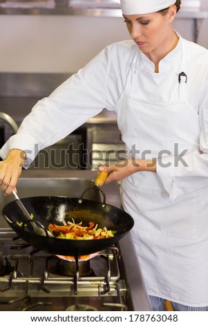 Concentrated female chef preparing food in the kitchen