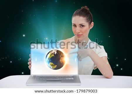 Digital composite of businesswoman pointing to her laptop showing earth graphic, elements of this image furnished by NASA