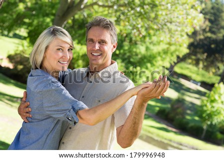 Portrait of happy couple dancing in park