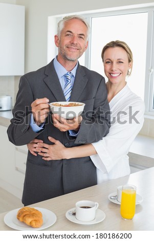 Smiling couple having breakfast in the morning before work at home in the kitchen