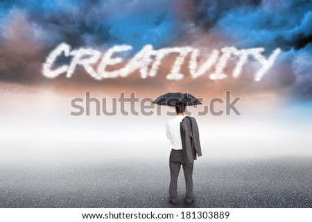 The word creativity and businessman standing back to camera holding umbrella and jacket on shoulder against cloudy landscape background