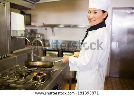 Side view portrait of a female cook preparing food in the kitchen