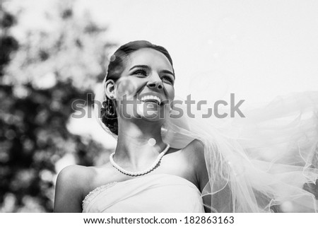 Close-up of a cheerful young beautiful bride in the park