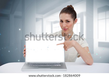 Digital composite of businesswoman pointing to her laptop