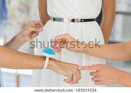 Closeup of two fashion designers adjusting dress on model in the studio