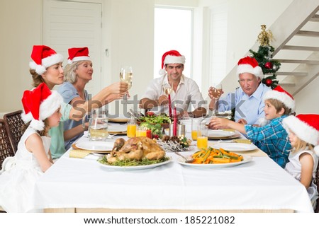 Multigeneration family toasting wine while having Christmas meal at home