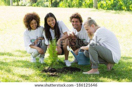 Portrait of happy volunteers planting in park