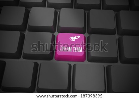 The word dream team and rocket ship on black keyboard with purple key