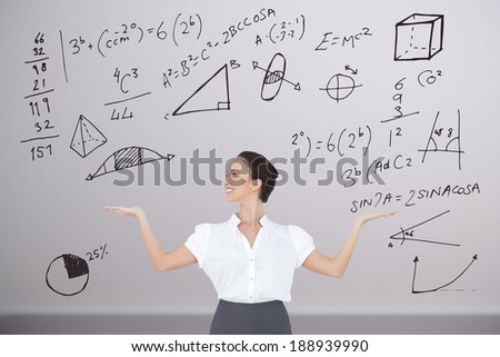 Happy elegant businesswoman posing with maths against room with wooden floor