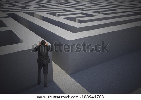 Stressed businessman with hands on head against entrance to difficult maze puzzle