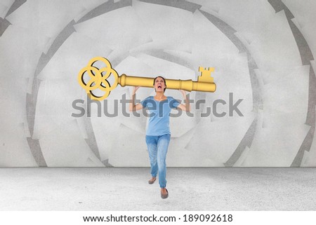 Annoyed brunette carrying large key against sheet spiral on grey wall