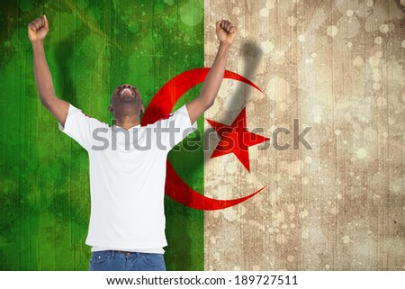 Excited handsome football fan cheering against algeria flag in grunge effect