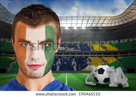 Composite image of serious young ivory coast fan with face paint against large football stadium